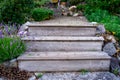 Weathered, wood garden steps on a cottage vacation property, showing several plants in a landscaped pathway. Symbolic of peace,