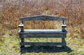 Weathered wooden bench in Texas prairie grass with morning sunlight