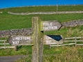 Weathered wooden fingerposts point the route of the Limestone Way and a public footpath in the Peak District in Derbyshire, UK.