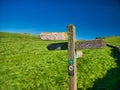 Weathered wooden fingerposts point the way to three different places in the Peak District in Derbyshire, UK. Taken on a sunny day