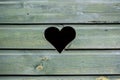 Weathered wooden green fence with heart shaped peephole Royalty Free Stock Photo