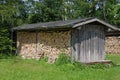Weathered Wooden Shed With Stacked Firewood