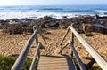 Weathered Wooden Stairway Leading onto Rocky Beach Royalty Free Stock Photo