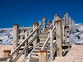 Weathered wooden steps give access to the beach at Camber Sands in East Sussex on the south coast of the UK.