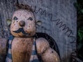 Weathered wooden vintage weightlifter puppet in front of birdhouse