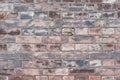 A weathered worn red stone wall in closeup