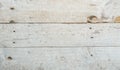 weathered and worn wooden surface with visible cracks, holes, and scratches, typical of an old workbench or floor