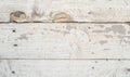 weathered and worn wooden surface with visible cracks, holes, and scratches, typical of an old workbench or floor