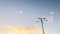 Weathervane with sunset orange color clouds.