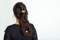 Weave, braid tail hairstyle. Hairstyle on brown hair woman with long hair on a white ay background. Professional hairdressing Royalty Free Stock Photo