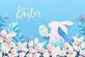Happy Easter festive background. Cute bunny in spring nature holds an easter egg in its paws.