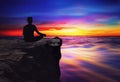 Yoga man silhouette meditating at sunset colorful sky and water reflection Royalty Free Stock Photo