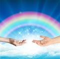 Magical love healing energy from hands with rainbow sky background