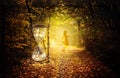 Magical hourglass and female guide in the enchanted forest, portal, divine timing Royalty Free Stock Photo