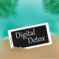 Phone in the sand, the inscription Digital Detox on the screen. The concept of a digital detox. The idea of turning off the gadget