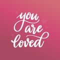 Hand lettering quote `You are loved` on pink background