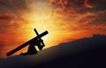 Jesus Christ carrying His cross on the hill, dramatic sky, sun rays light Royalty Free Stock Photo
