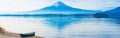 web banner alone boat mooring on ground at side of lake kawaguchi on morning time with fuji mountain background Royalty Free Stock Photo