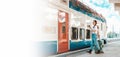 Web banner of travel with mock up. Young pretty woman walking to departure holds her luggage and using cellphone. Train Royalty Free Stock Photo
