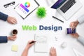 Web design text on work desk surrounded with web development team Royalty Free Stock Photo