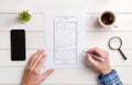 The web designer sketches the user interface on the wireframe of the mobile phone Royalty Free Stock Photo