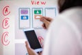 Web designer woman doing test sketch drawing application for mobile phone in office. User experience Design concept