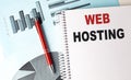WEB HOSTING text on a notebook with pen on a chart background Royalty Free Stock Photo
