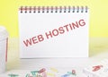 WEB HOSTING text on a notebook standing on a table on a yellow background Royalty Free Stock Photo