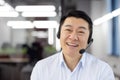 Webcam view, Asian support worker in shirt with headset smiling and looking at camera, businessman working inside office