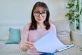 Webcam view of middle-aged woman holding clipboard, talking during video call