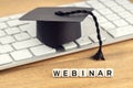 Webinar concept. Graduation cap on computer keyboard Royalty Free Stock Photo