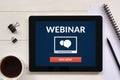 Webinar concept on tablet screen with office objects