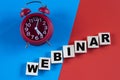 WEBINAR - word on wooden cubes on a multi-colored background with an alarm clock Royalty Free Stock Photo