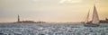 Website banner of sea with floating yachts and statue of liberty in background.