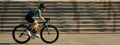 Website header of Side view of professional female cyclist in cycling garment and protective gear riding bicycle in city