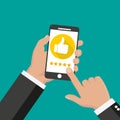 Website rating feedback and review concept. Hand holding and pointing to a smartphone with 5 star rating