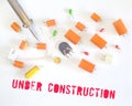 Website under construction sign with defective capacitors and soldering iron Royalty Free Stock Photo