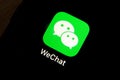 Wechat messenger application icon on Apple iPhone X smartphone screen close-up.