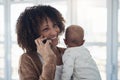 Wed love to see you. a young woman using a smartphone while carrying her adorable baby girl at home. Royalty Free Stock Photo