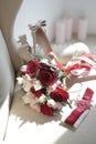 A bride`s bouquet of red and pink roses, women`s shoes, a garter of the bride Royalty Free Stock Photo