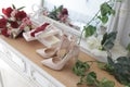 A bride`s bouquet of red and pink roses, women`s shoes, a garter of the bride