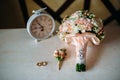 Wedding accessories. Boutonniere, Golden rings, a beautiful bouquet of flowers on white textured table. Concept of bride Royalty Free Stock Photo