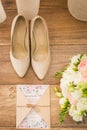 Wedding accessories: bridal shoes, rings, invitation, rings. Wedding details in beige shades. View from above