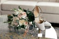 Wedding accessories of the bride in the form of a bouquet of roses, high-heeled shoes, wedding rings and perfume Royalty Free Stock Photo