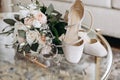 Wedding accessories of the bride in the form of a bouquet of roses, high-heeled shoes, wedding rings and perfume Royalty Free Stock Photo