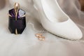 White shoes, perfume, wedding rings on a light background