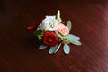 Wedding accessories of the budo of red, white and pink flowers for the groom with a ring on a dark wooden background Royalty Free Stock Photo