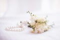 Wedding accessories. A string of pearls and the bride's bouquet. Royalty Free Stock Photo