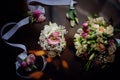 Wedding accessory bride. Stylish beige shoes, earrings, gold rings, flowers, garter, perfumes on table standing on wooden Royalty Free Stock Photo