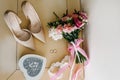 Wedding accessory. Classic shoes, bouquet bride`s on pastel table.
